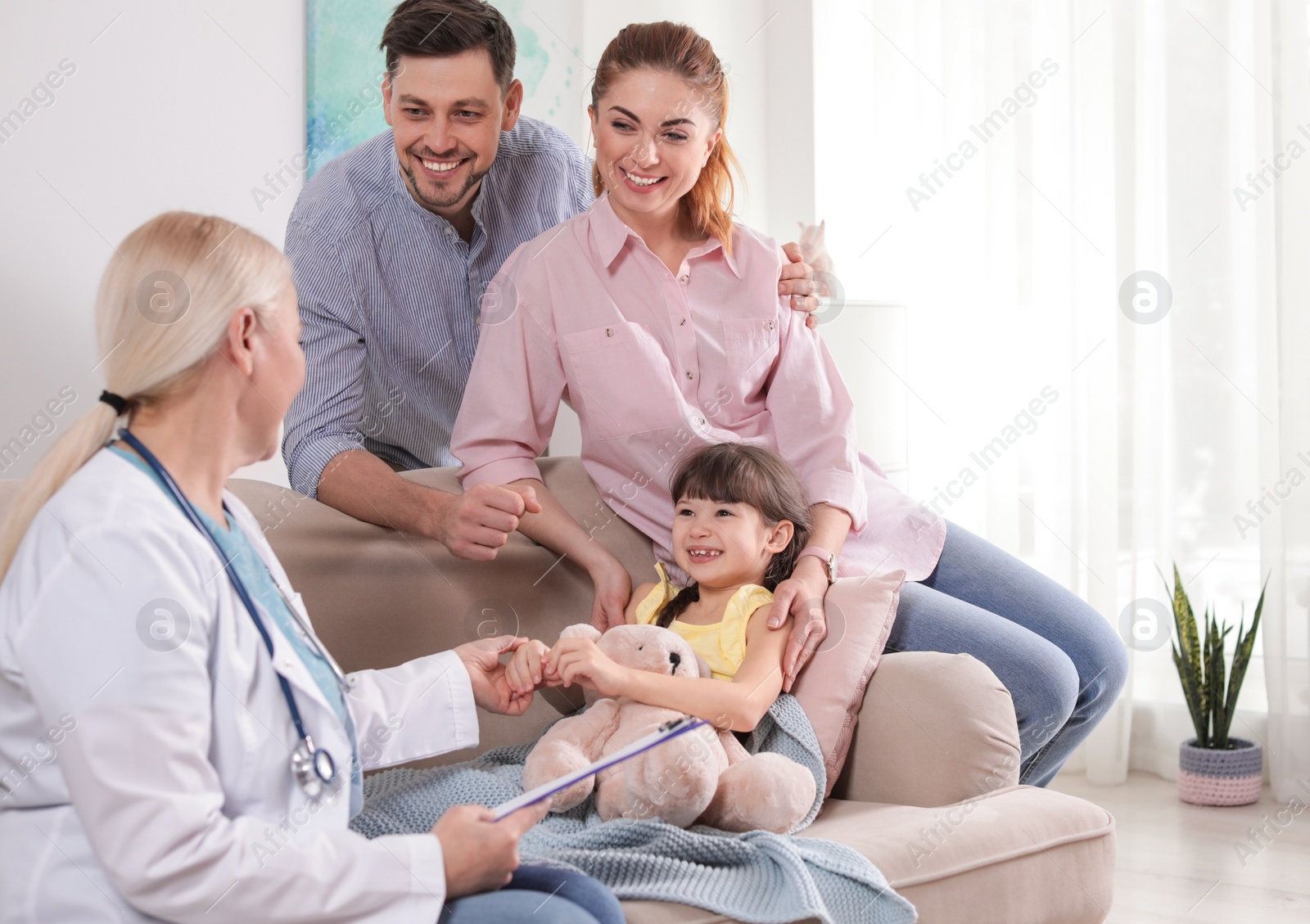 Photo of Family doctor visiting ill child at home