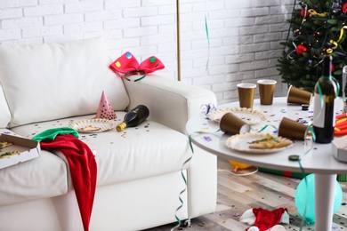 Photo of Messy living room interior with Christmas tree. Chaos after party