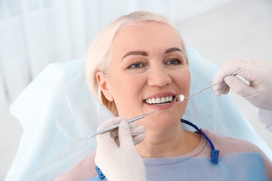 Dentist examining patient's teeth in modern clinic