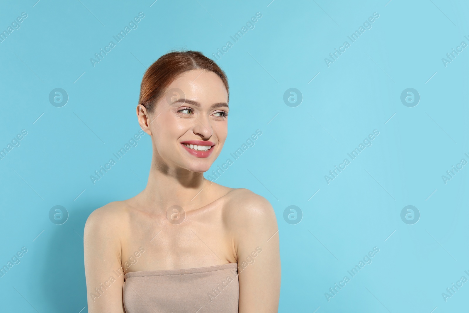 Photo of Beautiful young woman on light blue background, space for text