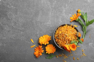 Photo of Dry and fresh calendula flowers on grey table, flat lay. Space for text
