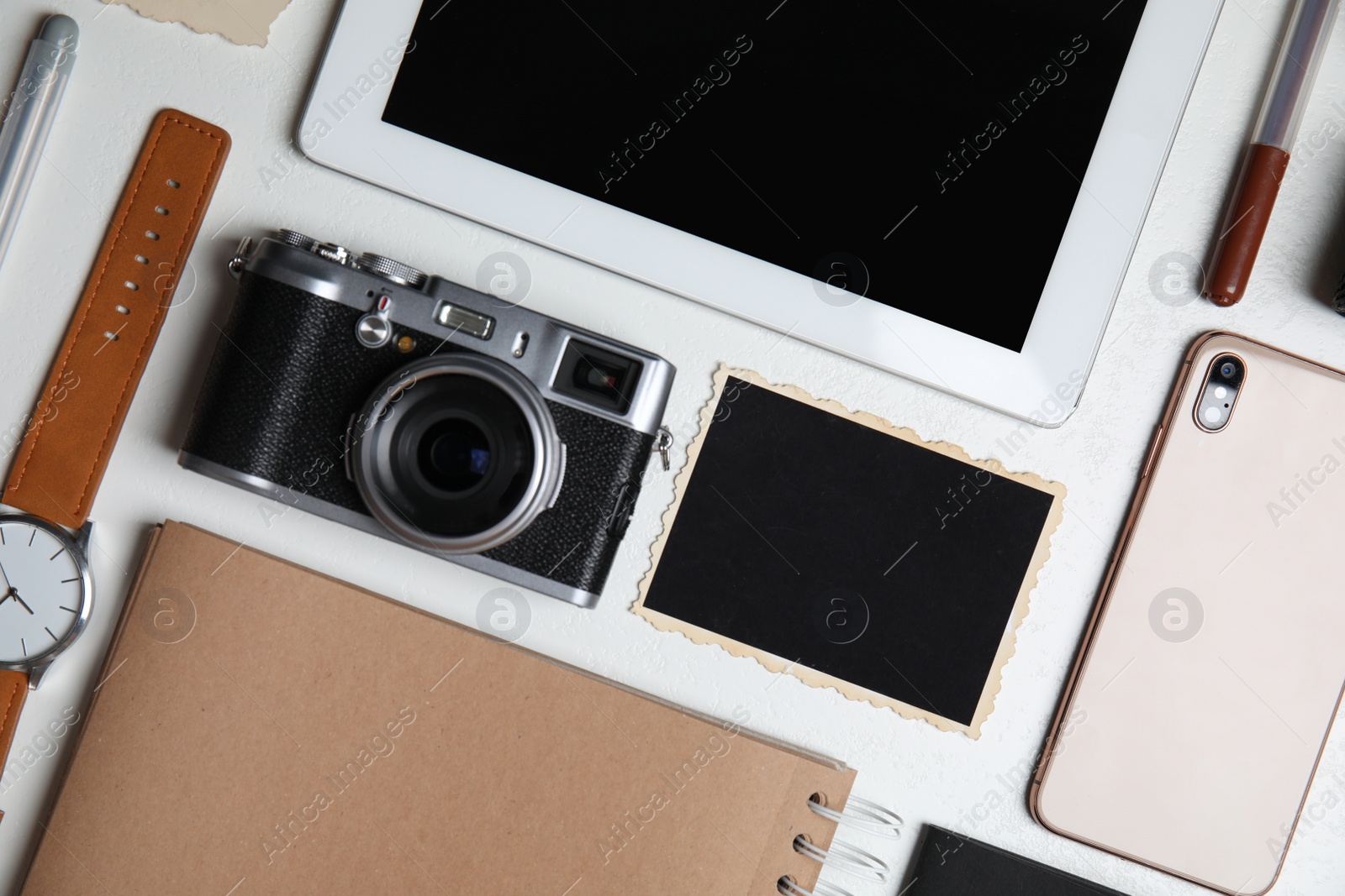 Photo of Flat lay composition with tablet, camera and smartphone on white table. Designer's workplace