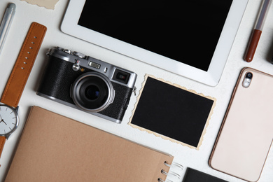 Photo of Flat lay composition with tablet, camera and smartphone on white table. Designer's workplace