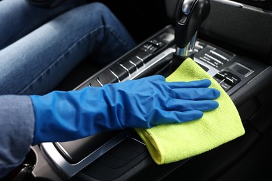 Photo of Woman wiping her modern car with rag, closeup