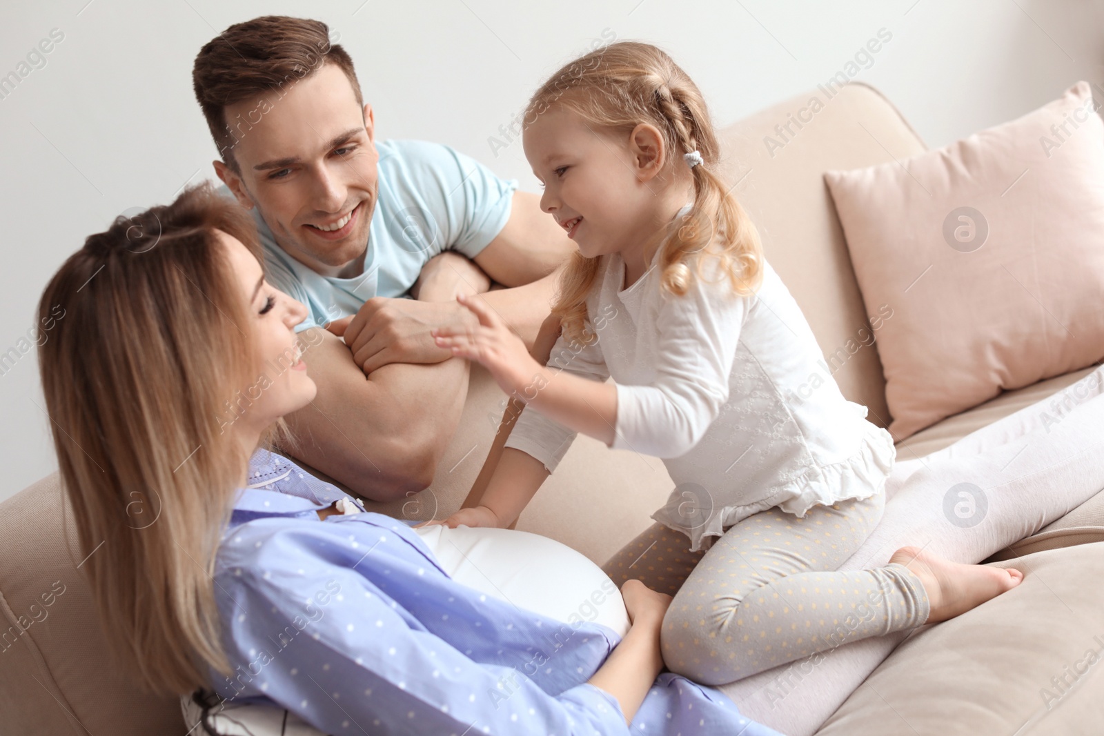 Photo of Young pregnant woman with her family at home