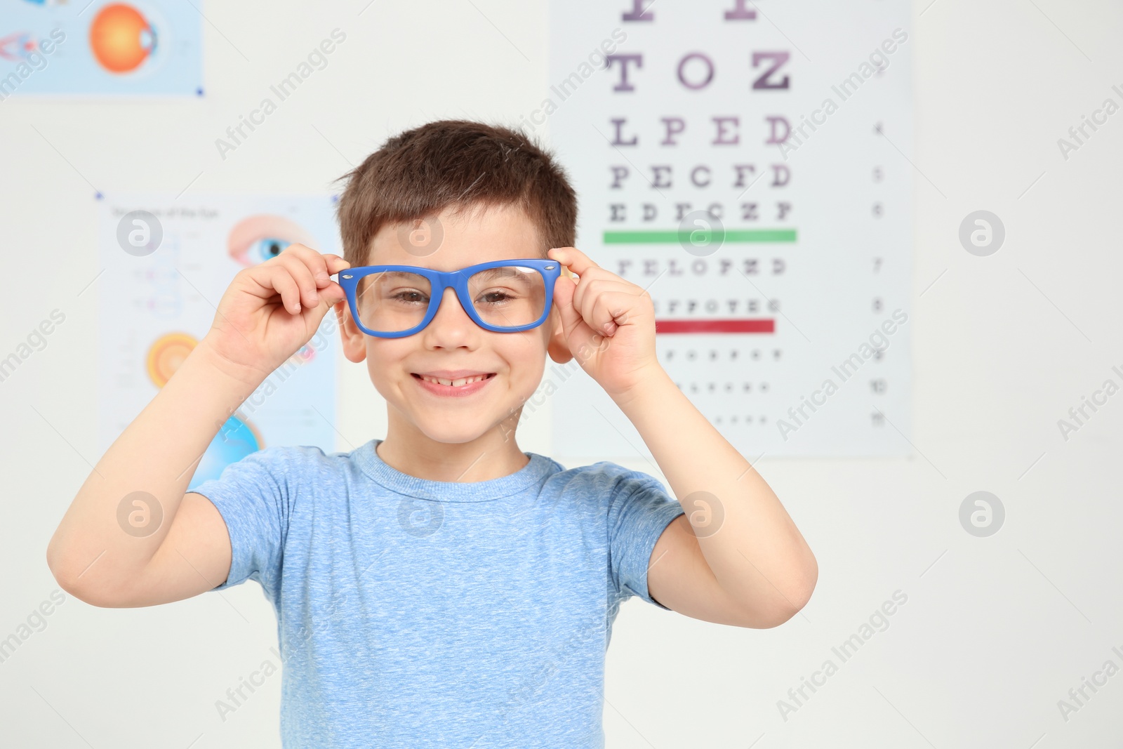 Photo of Cute little boy with glasses visiting ophthalmologist