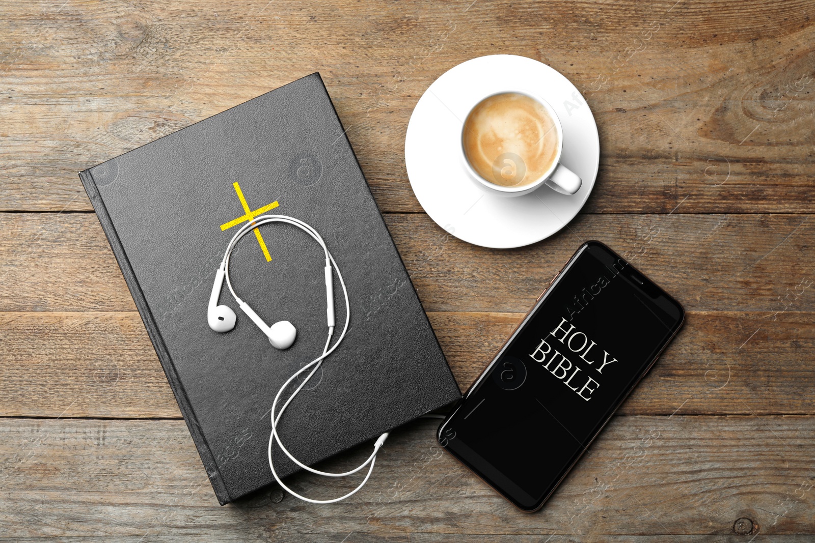 Photo of Bible, phone, cup of coffee and earphones on wooden background, flat lay. Religious audiobook