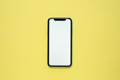 Photo of MYKOLAIV, UKRAINE - JULY 07, 2020: iPhone 11 on yellow background, top view. Mockup for design