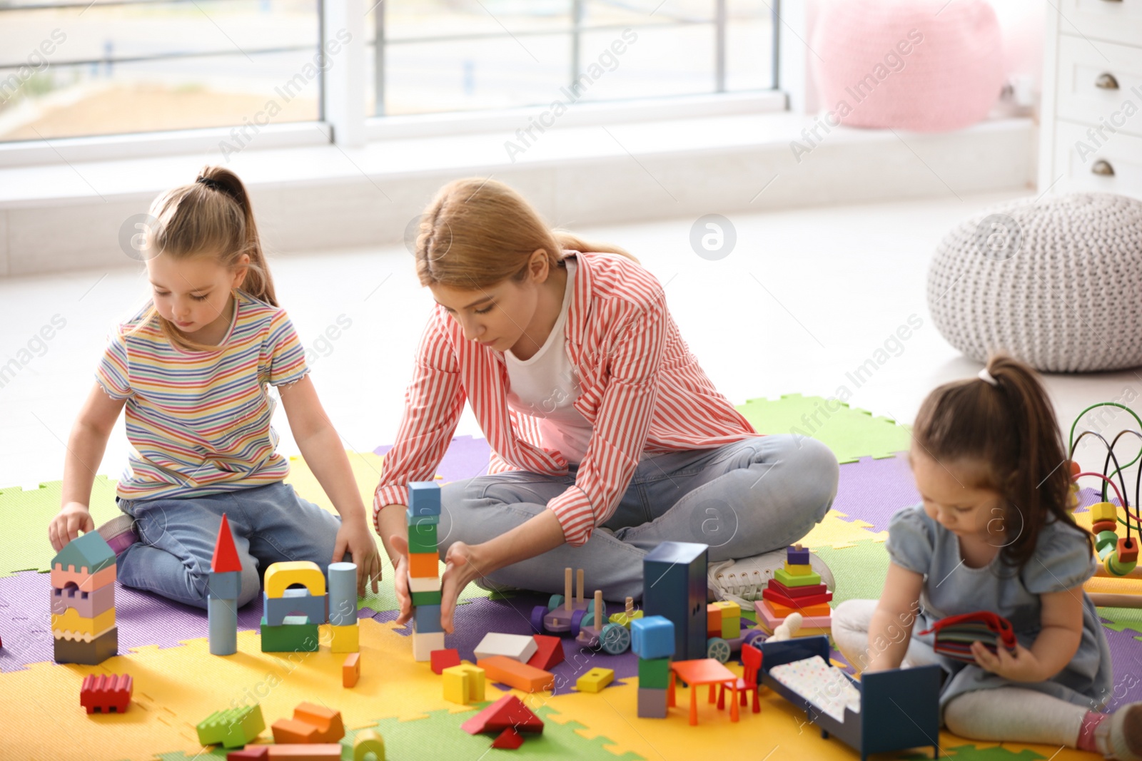 Photo of Mother playing with her children at home