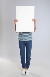 Photo of Woman holding blank poster on light grey background