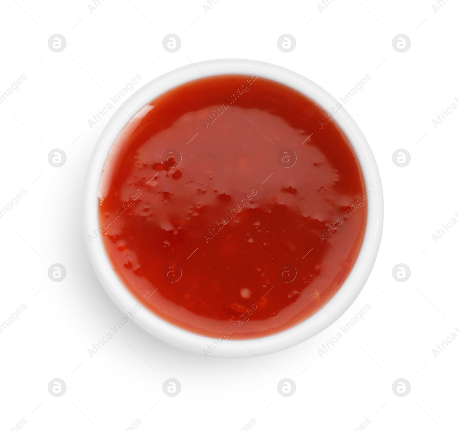 Photo of Spicy chili sauce in bowl isolated on white, top view