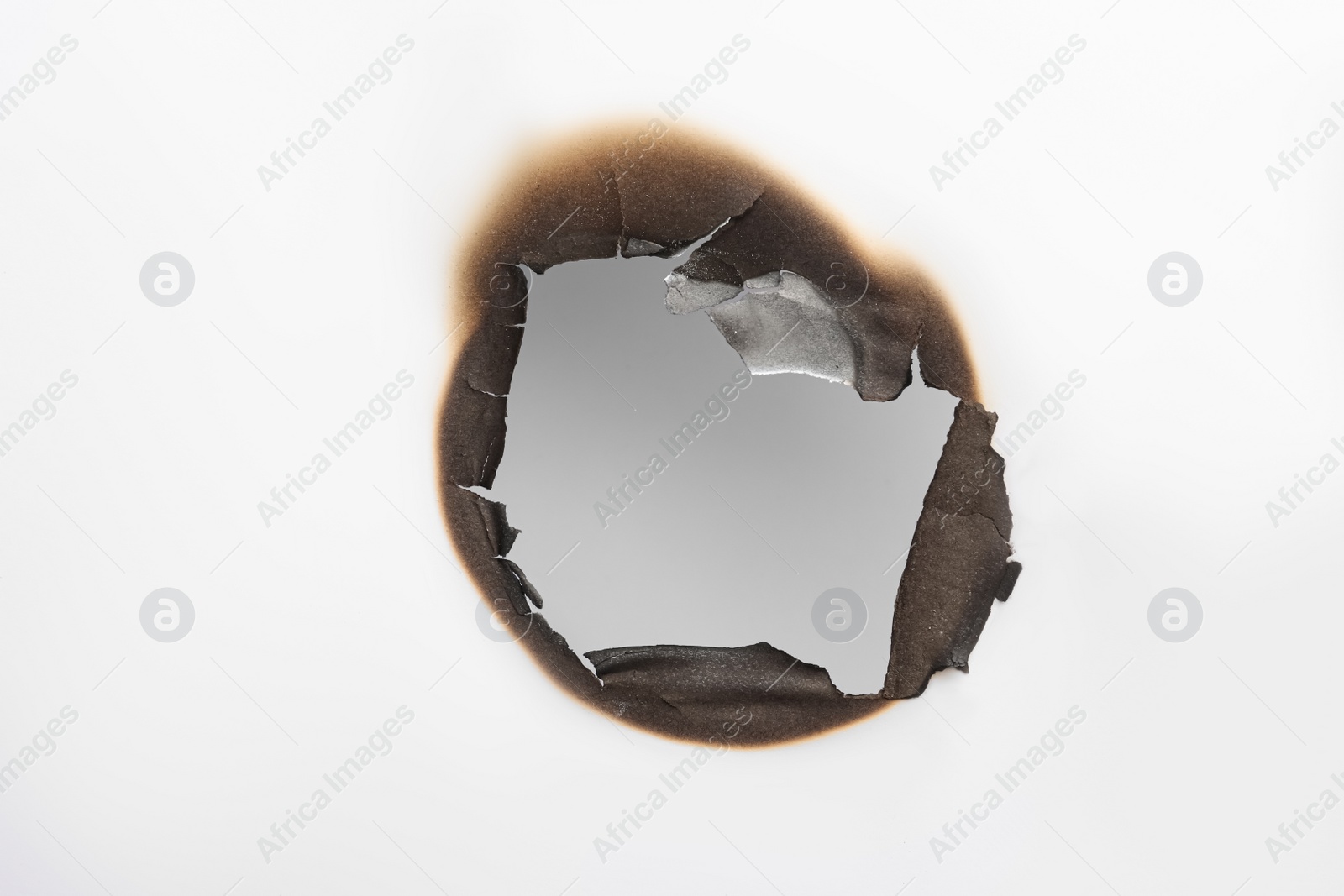 Photo of Burnt hole in paper on white background