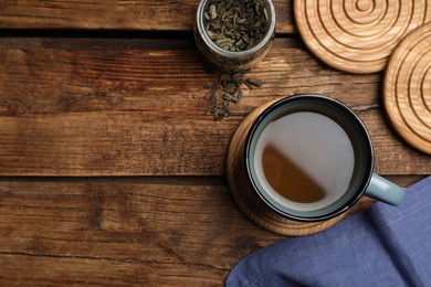 Mug of hot drink and stylish cup coasters on wooden table, flat lay. Space for text