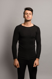 Man wearing thermal underwear on grey background