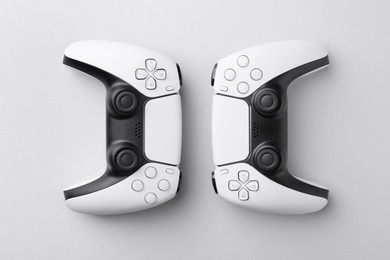 Photo of Wireless game controllers on light grey background, flat lay