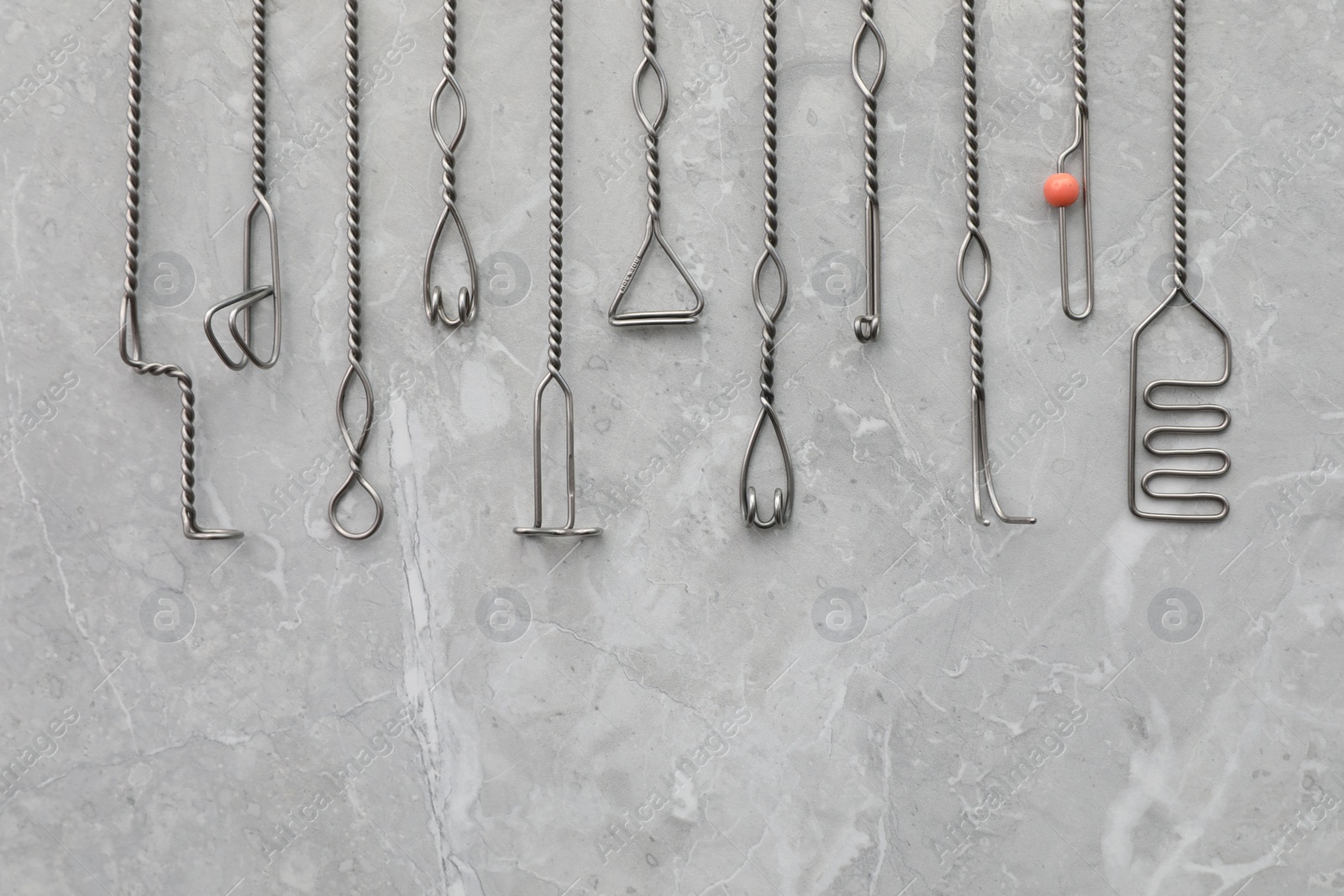 Photo of Set of different logopedic probes and space for text on marble table, flat lay. Speech therapist's tools