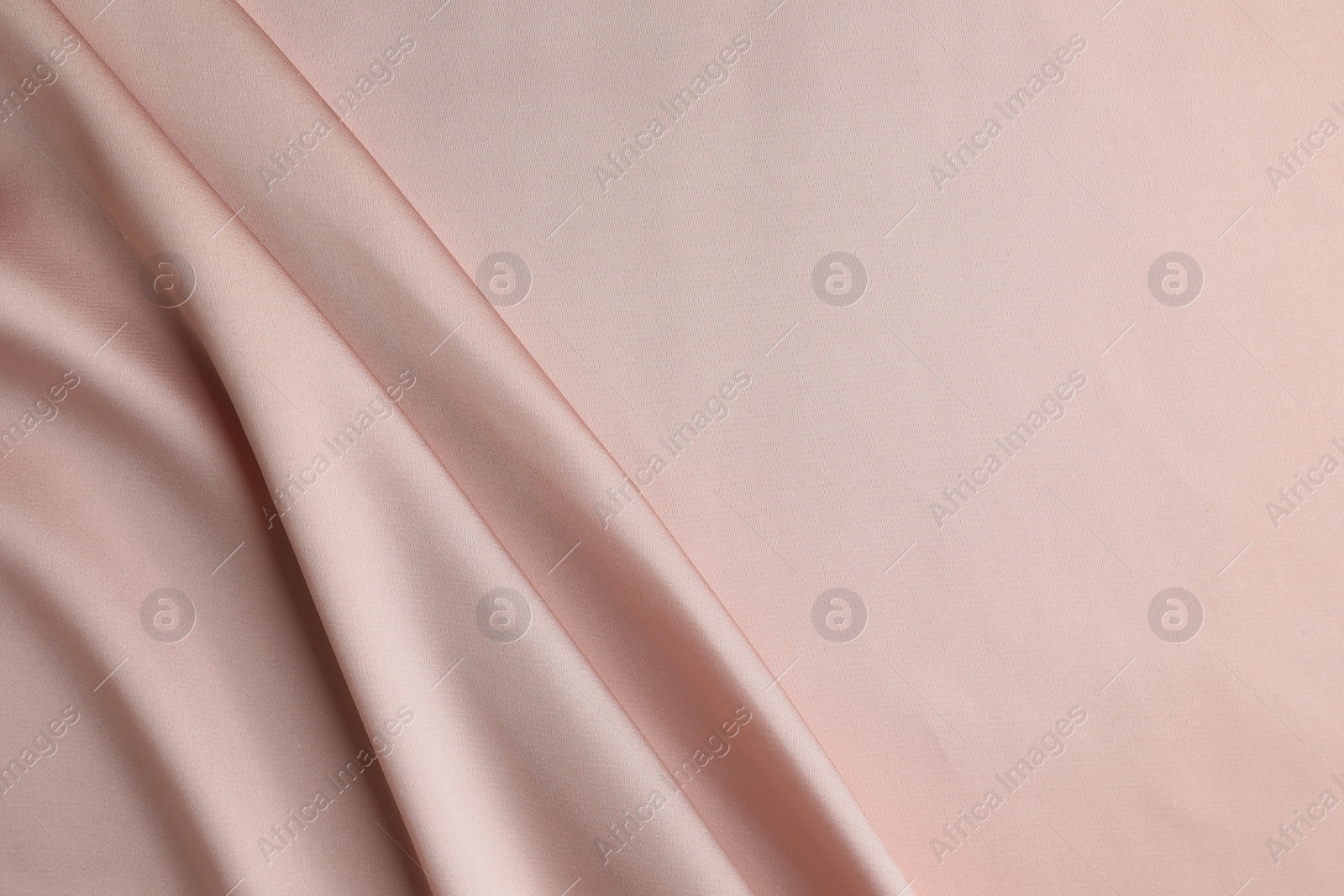 Photo of Crumpled pink silk fabric as background, top view. Space for text