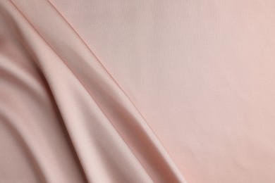 Crumpled pink silk fabric as background, top view. Space for text