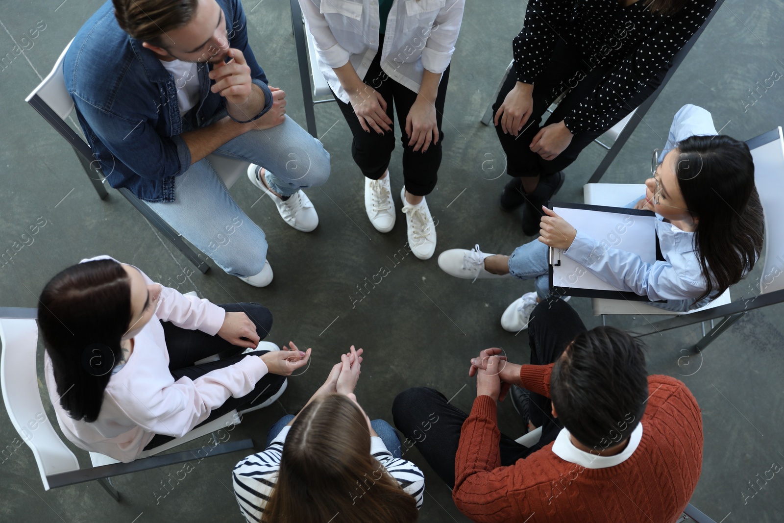 Photo of Psychotherapist working with patients in group therapy session, top view