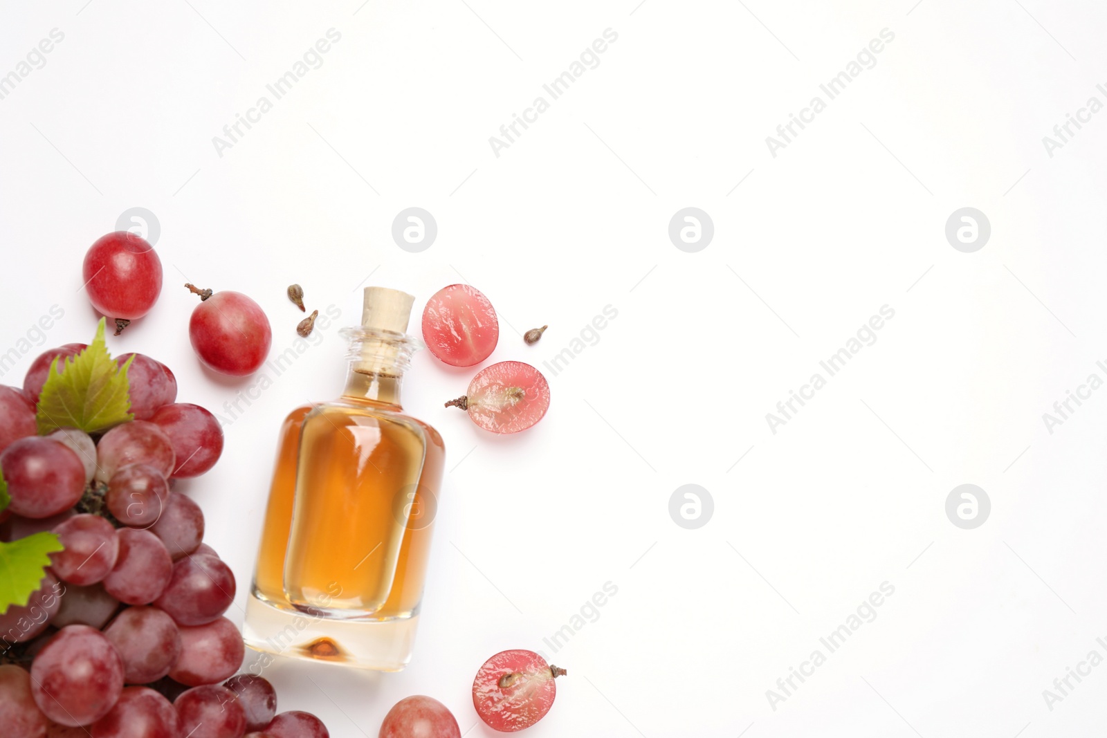 Photo of Composition with bottle of natural grape seed oil on white background, top view. Organic cosmetic