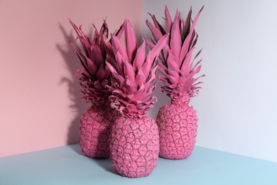 Photo of Pink pineapples on color background. Creative concept