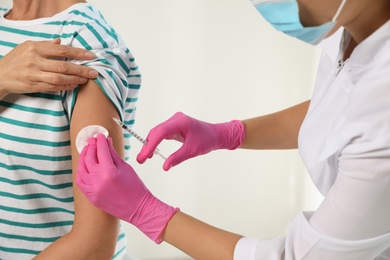 Photo of Doctor giving injection to patient in hospital, closeup. Vaccination day