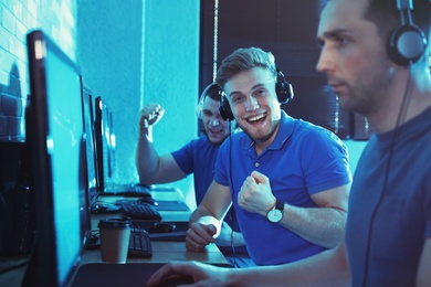 Group of people playing video games in internet cafe