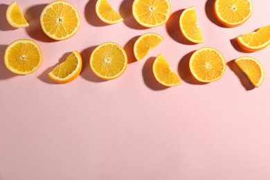 Photo of Cut fresh ripe oranges on pink background, flat lay. Space for text