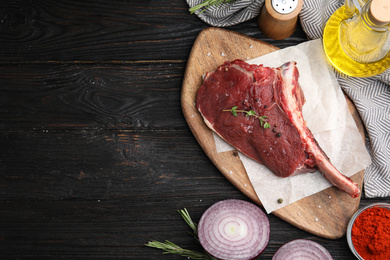 Flat lay composition with fresh beef cut on wooden table. Space for text