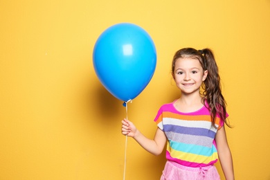 Cute girl with balloon on color background. Birthday celebration