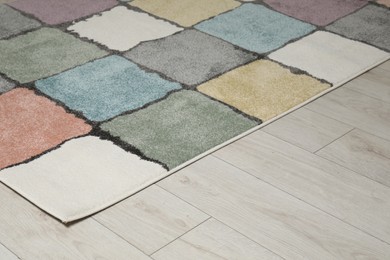 Soft carpet with pattern on white laminated floor indoors, space for text