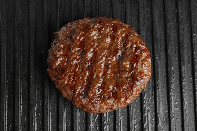 Photo of Prepared meat cutlet for burger on grill, closeup