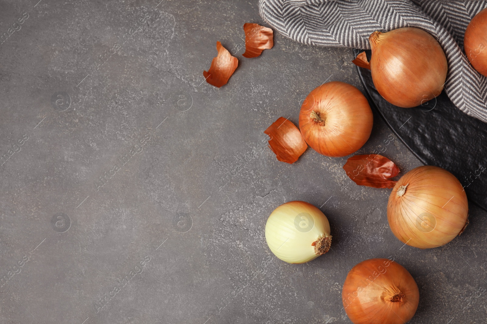 Photo of Flat lay composition with ripe onions on grey table, space for text