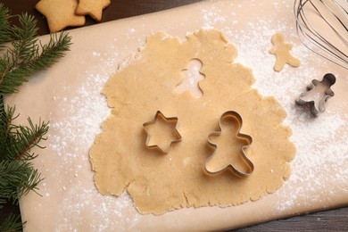 Making Christmas cookies. Flat lay composition with cutters and raw dough on wooden table