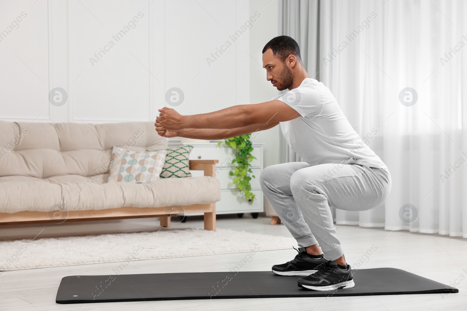 Photo of Man doing morning exercise on fitness mat at home