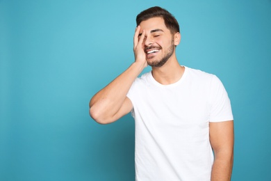 Photo of Portrait of young man laughing on color background