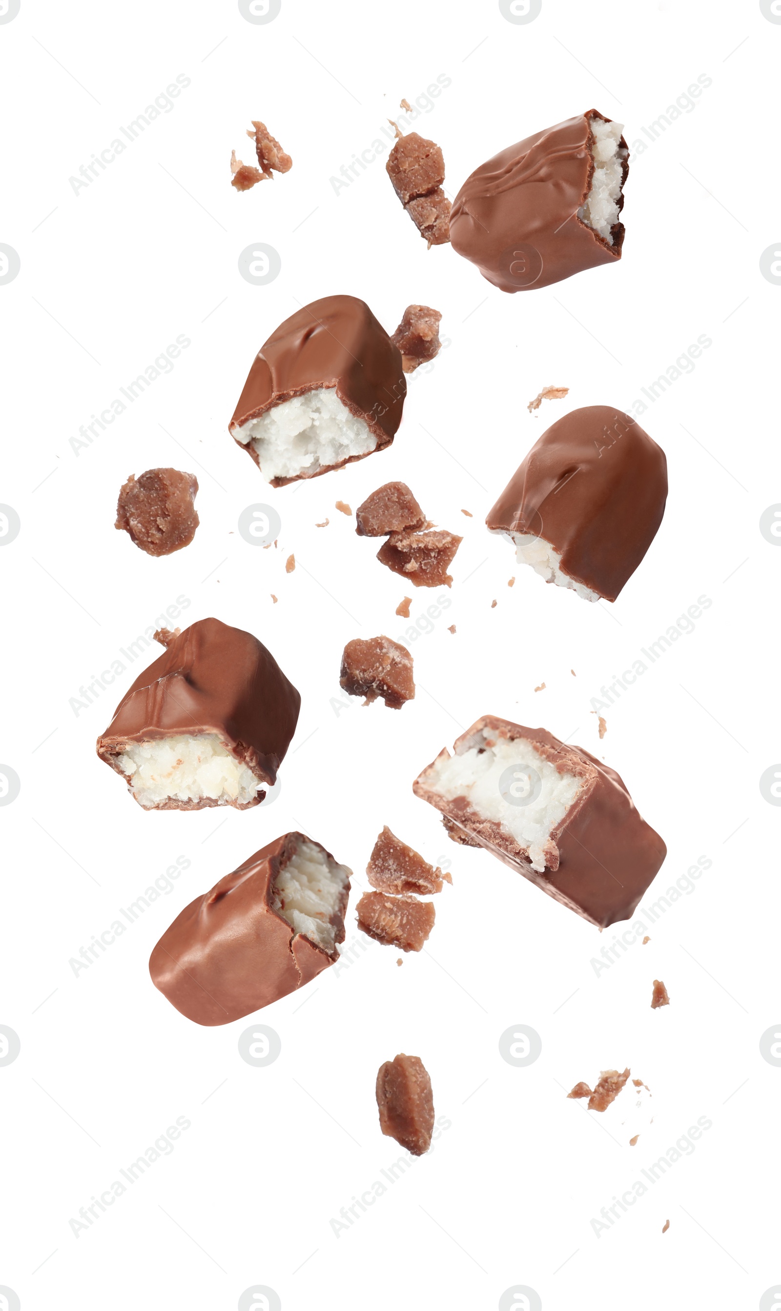 Image of Pieces of delicious chocolate bars with coconut filling falling on white background