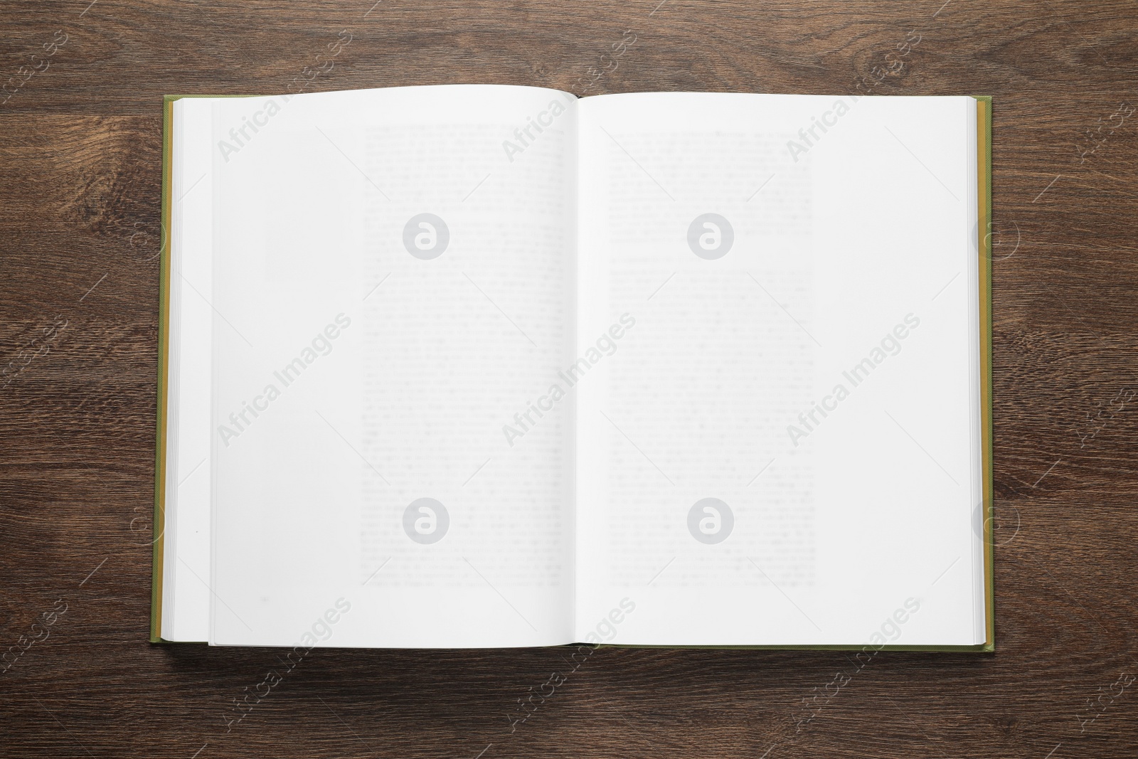 Photo of Open book on wooden table, top view