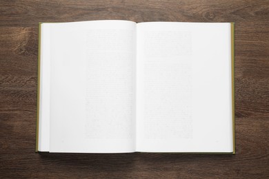 Photo of Open book on wooden table, top view