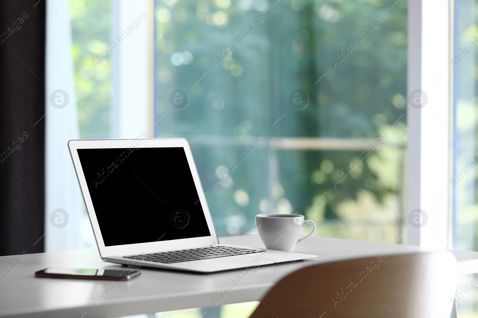 Photo of Comfortable workplace with modern laptop on desk in home office, space for text