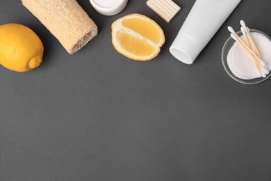 Photo of Lemon face wash. Fresh citrus fruits and personal care products on dark grey background, flat lay. Space for text