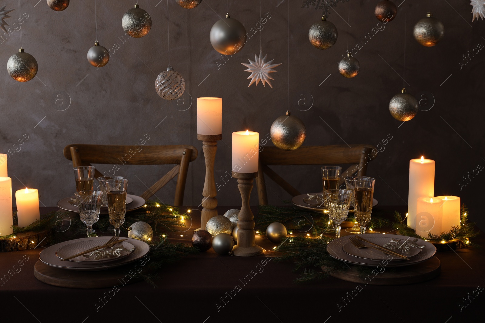 Photo of Christmas table setting with burning candles and festive decor