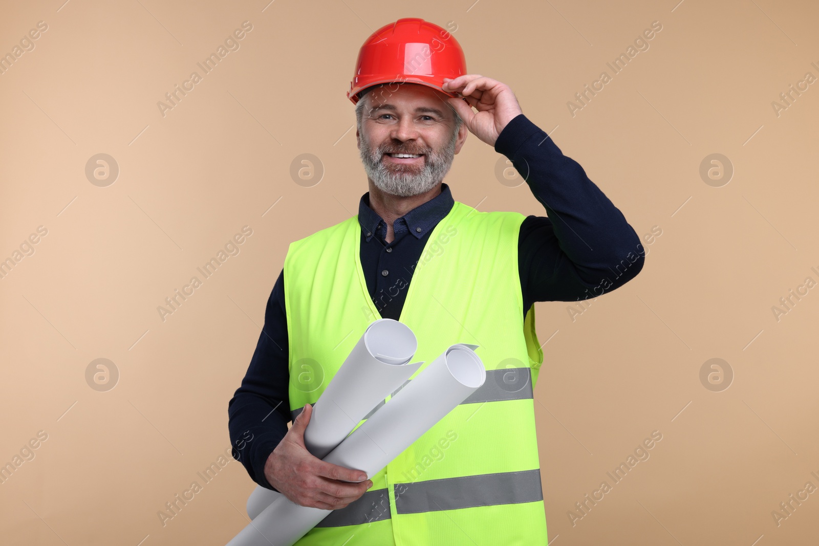 Photo of Architect in hard hat holding drafts on beige background