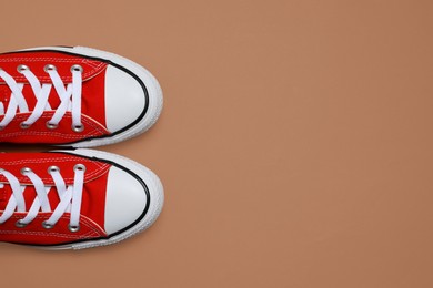 Photo of Pair of new stylish red sneakers on beige background, flat lay. Space for text