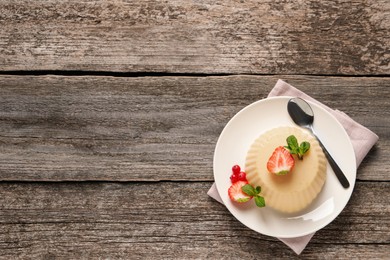 Photo of Delicious semolina pudding with berries on wooden table, top view. Space for text