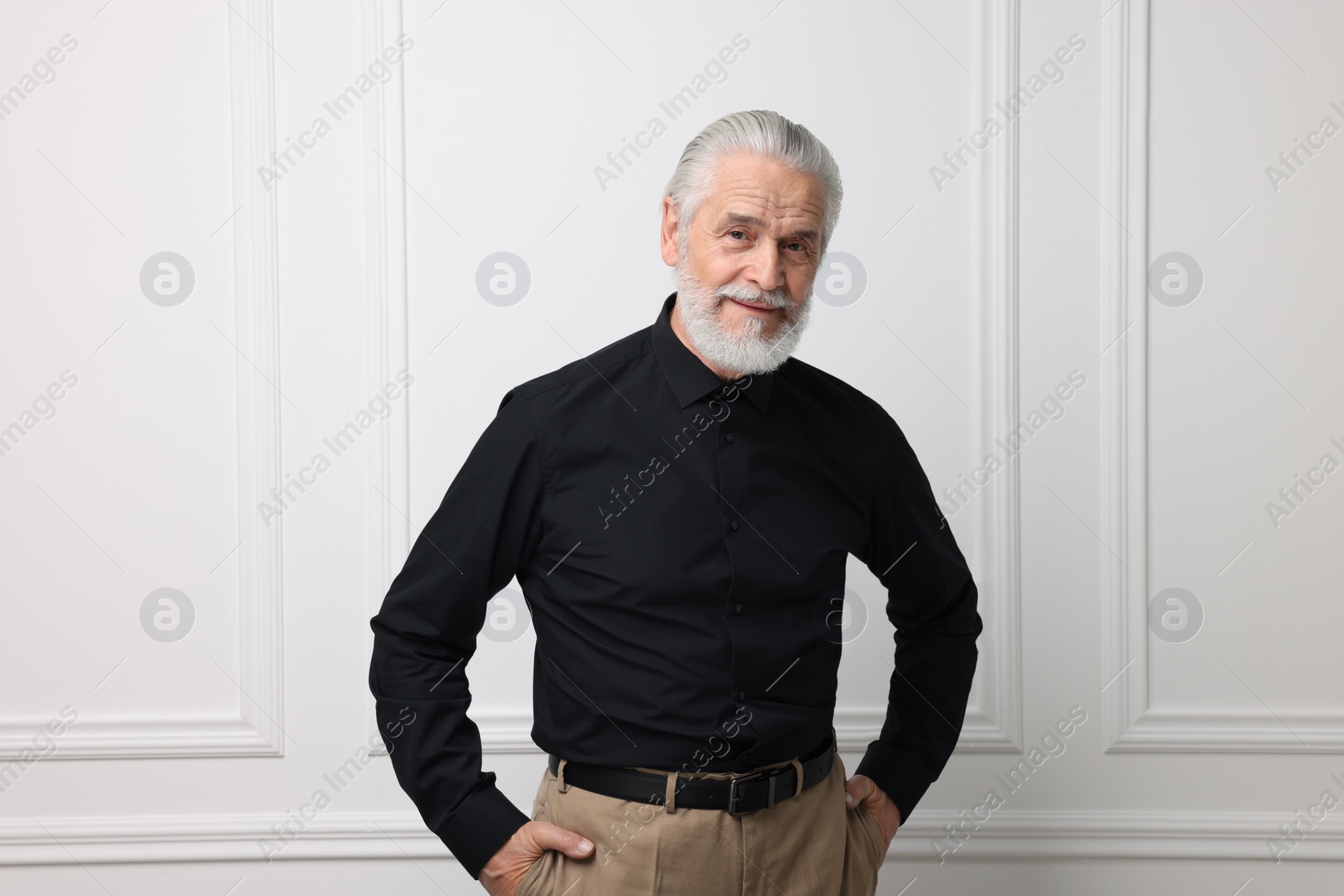 Photo of Portrait of handsome senior man near white wall