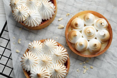 Tartlets with meringue on white wooden table, top view. Delicious dessert