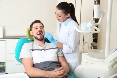 Professional dentist working with patient in modern clinic