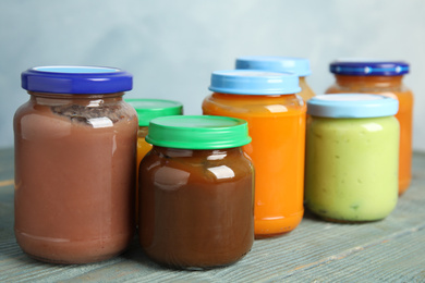 Photo of Jars with baby food on wooden table