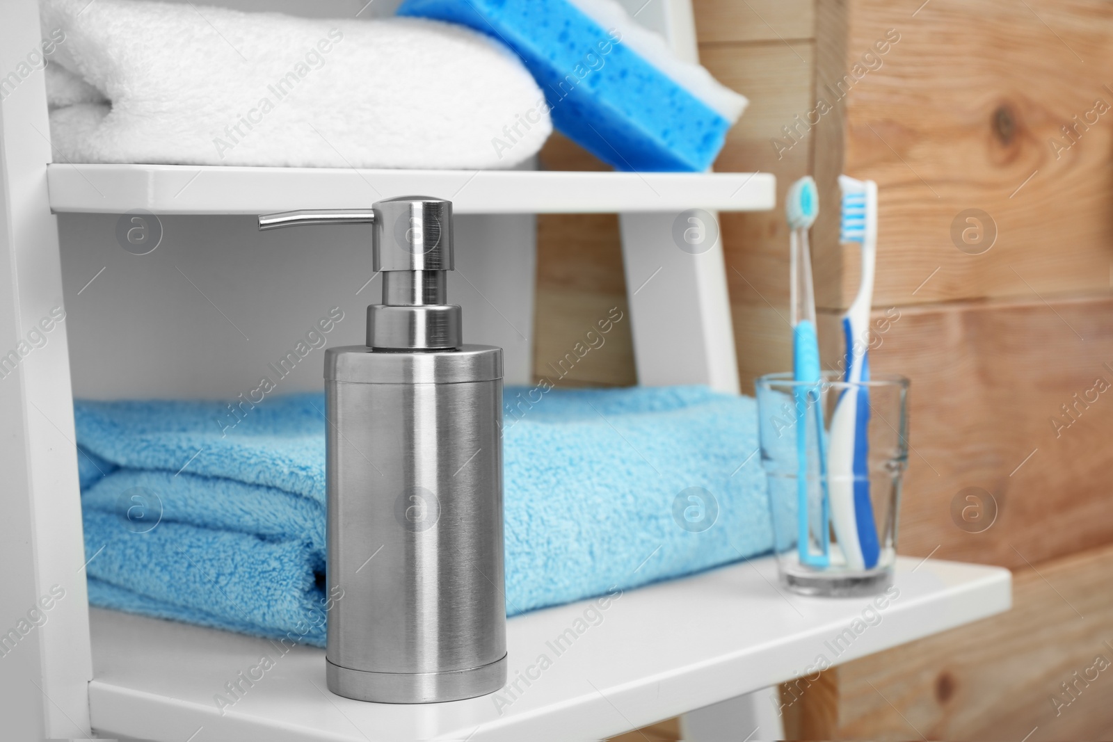 Photo of Towel and soap dispenser on shelf in bathroom